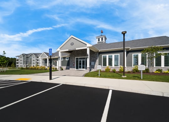 the front of a building with a parking lot and street signs at The Oasis at Plymouth, Plymouth, 02360