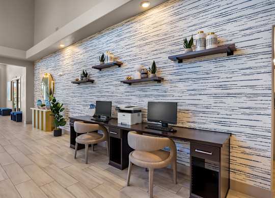 A modern office with a white brick wall and wooden floors.