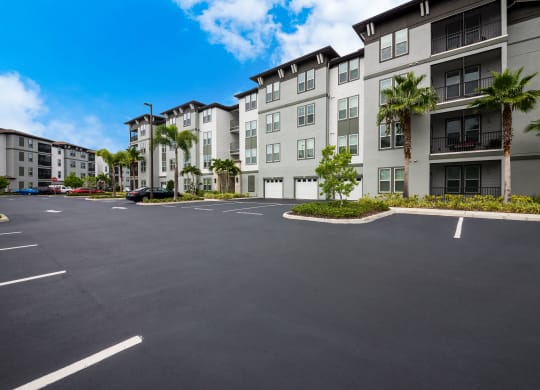 an empty parking lot in front of a large apartment building at The Oasis at Highwoods Preserve, Tampa, 33647