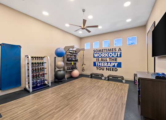 Yoga room with a variety of equipment and a motivational quote on the wall.