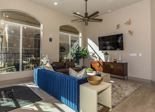 A living room with a blue couch and a ceiling fan.