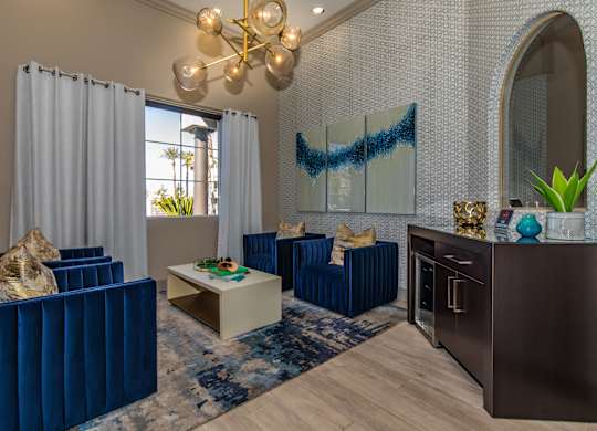 A living room with blue furniture and a chandelier.