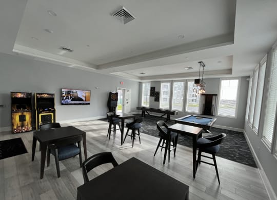 a large room with tables and chairs and a flat screen tv on the wall at The Oasis at Plymouth, Massachusetts