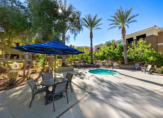 A patio with a table and chairs and a spa.