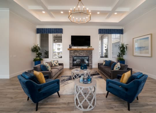 a living room with blue chairs and couches at The Oasis at Plymouth, Plymouth, MA