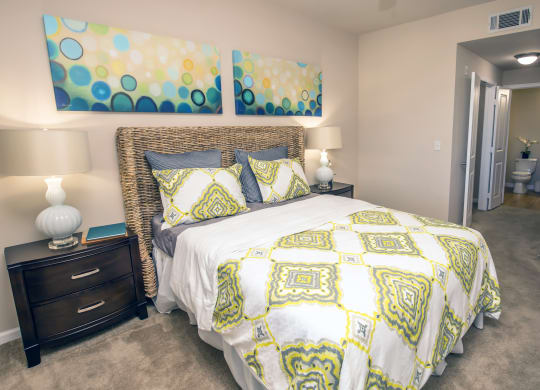 a yellow and white bed in a bedroom with a closet at Loreto & Palacio Apartments, Las Vegas, Nevada