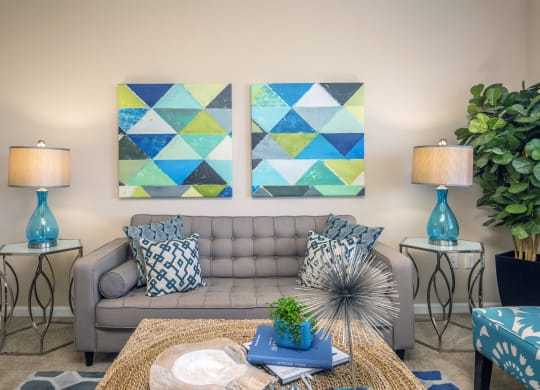 a living room with two paintings on the wall and a couch at Loreto & Palacio Apartments, Las Vegas, NV 89149