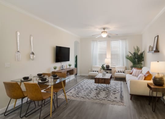 an open living room and dining room with a couch and a table at The Oasis at Town Center, Jacksonville, FL 32246