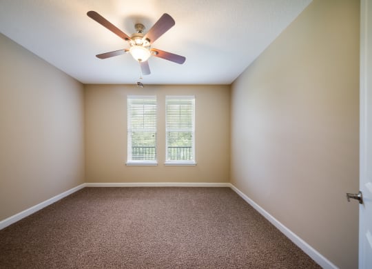 an empty room with a ceiling fan and a window at The Oasis at Highwoods Preserve, Tampa
