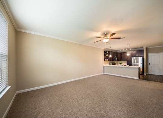 an empty living room and kitchen with a ceiling fan at The Oasis at Highwoods Preserve, Tampa, FL