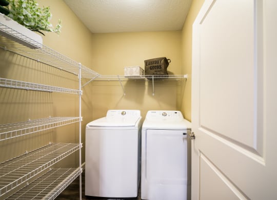a laundry room with two washers and dryers next to a door at The Oasis at Highwoods Preserve, Tampa, 33647