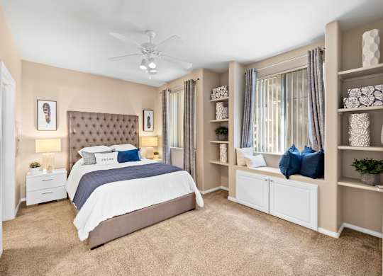 A bedroom with a large bed and a ceiling fan.