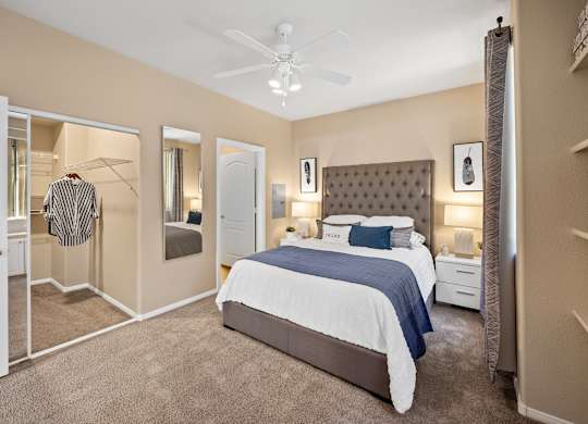 A bedroom with a large bed and a ceiling fan.
