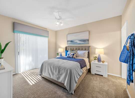 A bedroom with a large bed and a ceiling fan.