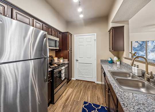 A kitchen with a stainless steel refrigerator and a white door.