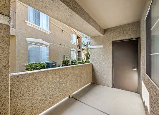 A balcony with a door and windows on a building.