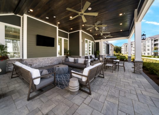 a covered patio with furniture and a tv at The Oasis at Plymouth, Massachusetts, 02360