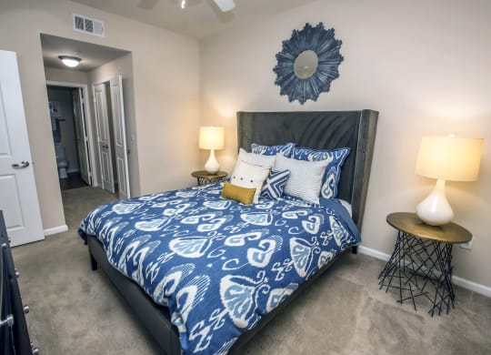 a bedroom with a bed with blue and white comforter and pillows at Loreto & Palacio Apartments, Las Vegas, 89149