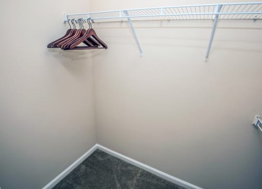 a walk in closet with a white wall and a rack and hangers at Loreto & Palacio Apartments, Las Vegas, Nevada