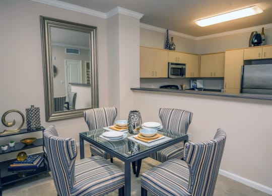 a dining room with a table and chairs and a kitchen at Loreto & Palacio Apartments, Las Vegas, Nevada