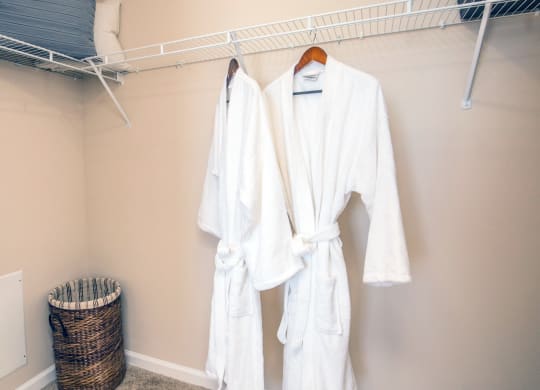 two white robes hanging on a rack in a closet at Loreto & Palacio Apartments, Las Vegas