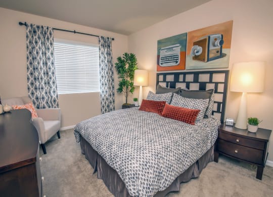 a bedroom with a bed and a desk and a window at Loreto & Palacio Apartments, Nevada 89149