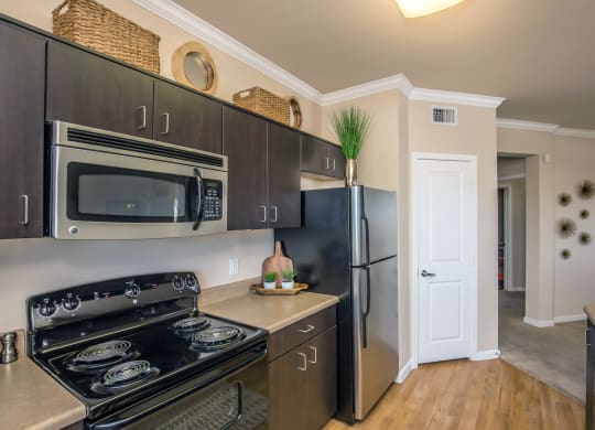a kitchen with stainless steel appliances and a black refrigerator at Loreto & Palacio Apartments, Las Vegas, NV