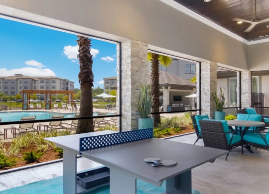 a patio with a table and chairs and a swimming poolat The Oasis at Town Center, Jacksonville, Florida