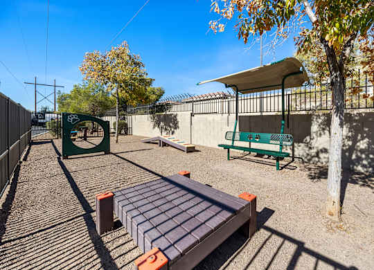 A playground with a slide, swings, and a seesaw.