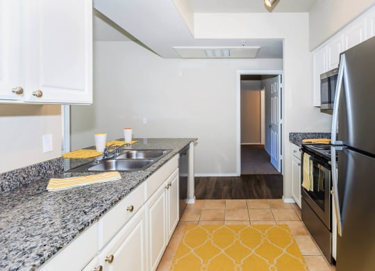 Kitchen appliances and cabinets with wooden flooring at The Aliante by Picerne, Scottsdale, AZ, 85259