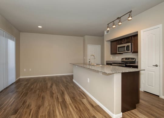 wooden cabinets and appliances in kitchen and dining areaat The Cantera by Picerne, Las Vegas, NV