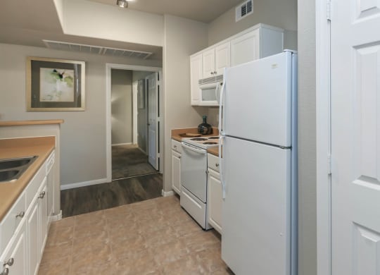 Kitchen with white appliances at The Covington by Picerne, Nevada, 89139