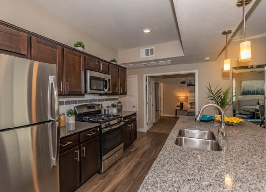 Kitchen with wooden cabinets and steel appliances at Level 25 at Cactus by Picerne, Las Vegas, NV, 89141