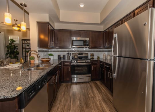 Kitchen with appliances and wooden cabinets1 at Level 25 at Cactus by Picerne, Las Vegas, 89141