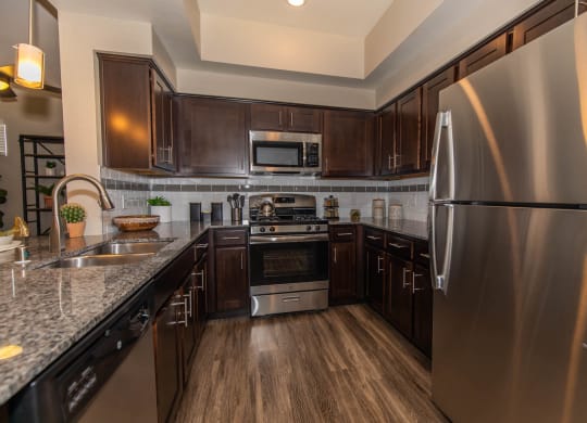 Kitchen with appliances and wooden cabinets at Level 25 at Cactus by Picerne, Las Vegas, NV