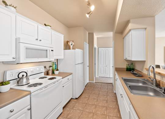A kitchen with white appliances and cabinets. at The Fairways by Picerne, Nevada, 89141