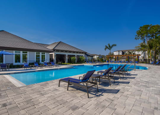 a resort style pool with lounge chairs and umbrellas  at The Oasis at Manatee River, Florida, 34211