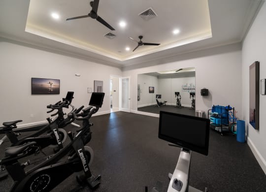 a gym with weights and cardio machines and a tv at The Oasis at Plymouth, Plymouth, Massachusetts