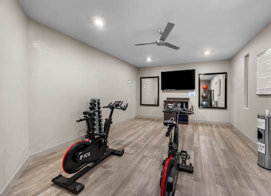 A room with a wooden floor and a wall-mounted TV.