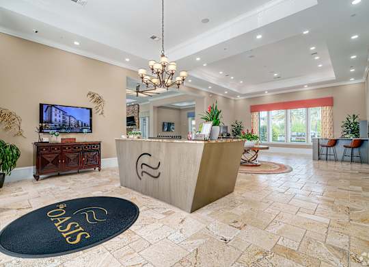 A reception area with a large screen TV and a reception desk.
