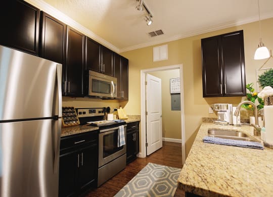 a kitchen with stainless steel appliances and granite counter tops at The Oasis at Moss Park, Orlando, 32832