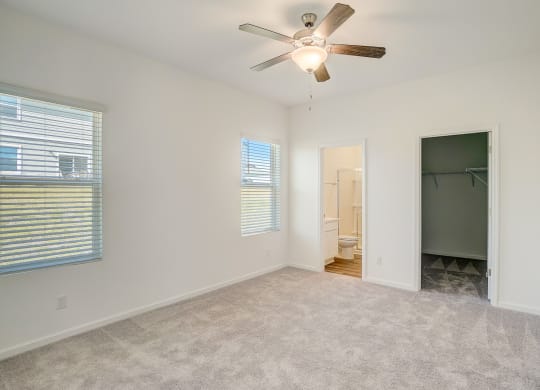 Bedroom with plush carpeting and ceiling fan in the Elm floor plan at Beacon at Clinton Corners in Dade City, FL