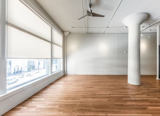 Mid Elm Lofts room with wood floors and a large window