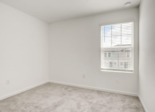 View of second bedroom with white walls and a window at Beacon at Arbours in Ruskin, FL