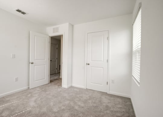 View of second bedroom with white doors and a carpeted floor at Beacon at Arbours in Ruskin, FL