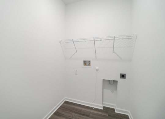 Laundry room with a shelf and full-size washer and dryer connections in the Oak floor plan at Beacon at Clinton Corners in Dade City, FL