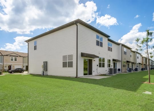 View behind our townhomes with a green lawn area at Beacon at Arbours in Ruskin, FL