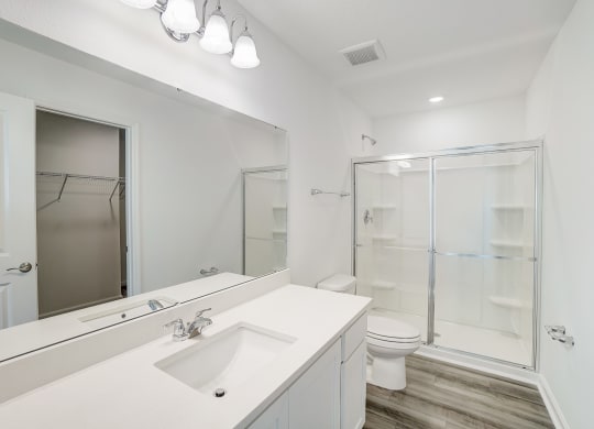 A bathroom with a sink and a stand-up shower in the Verbena floor plan at Beacon at Clinton Corners in Dade City, FL