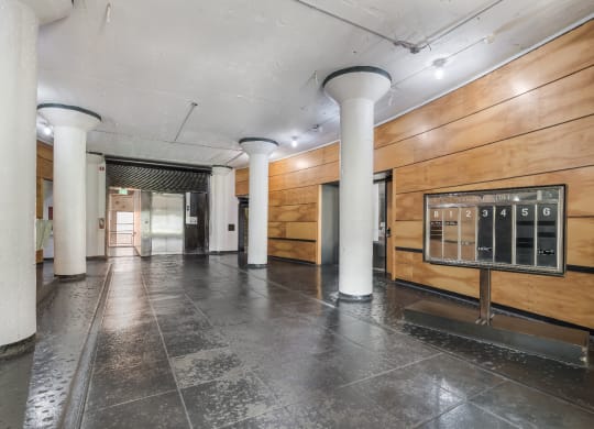 a large hallway with white pillars and a wood paneled wall