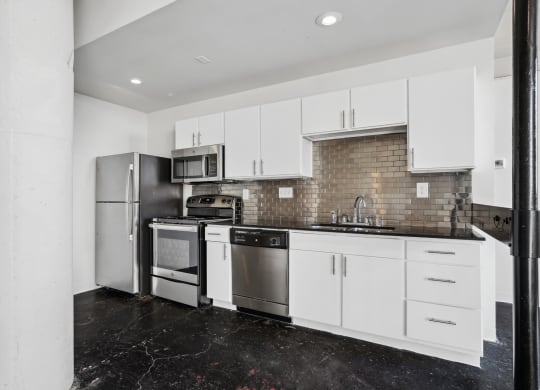 a kitchen with white cabinets and stainless steel appliances